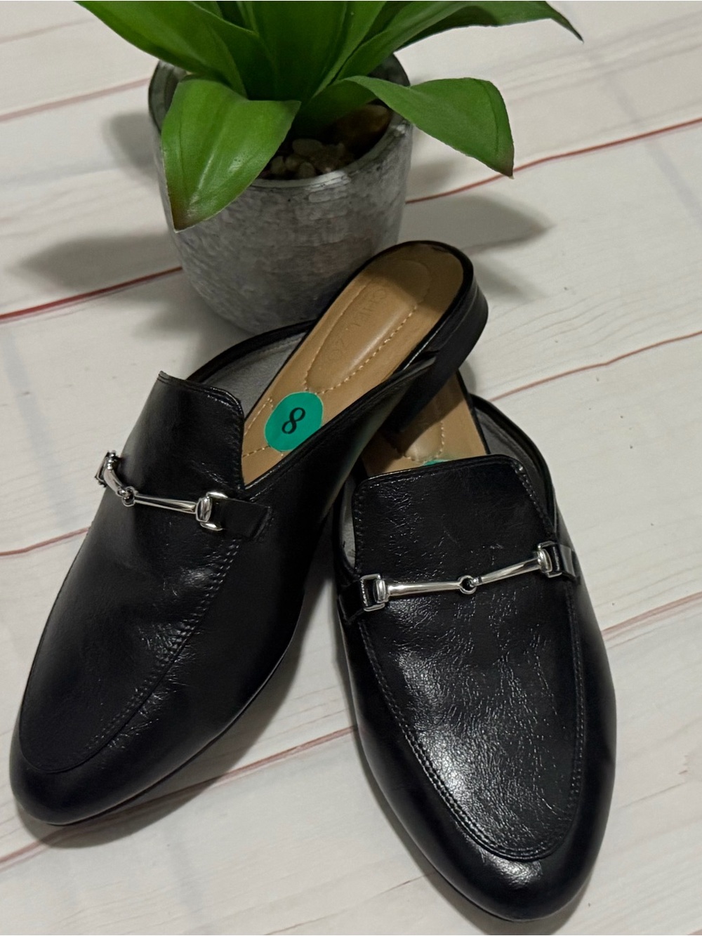 Women's black slip-on mules with silver stirrup detail